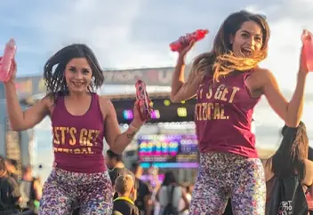 Two women in Ice sparkling water branded clothes at a live event